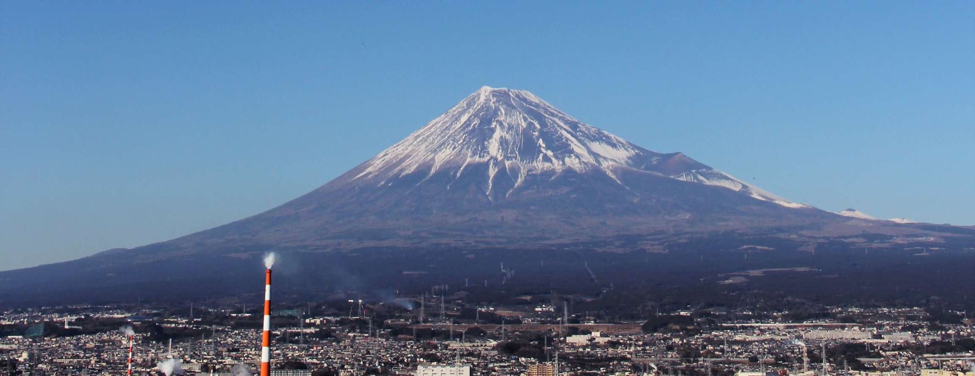 Gunung Fuji menjulang di atas kota pesisir Shizuoka pada siang hari