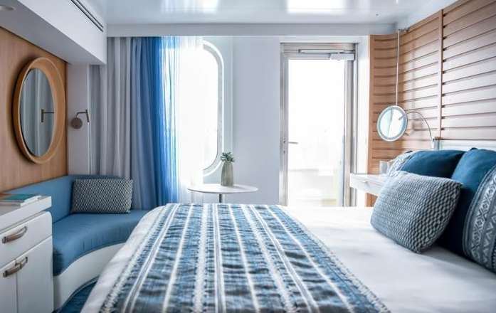 Kabin Prestige Le Jacques Cartier dengan karpet biru, kursi santai, dan jendela besar